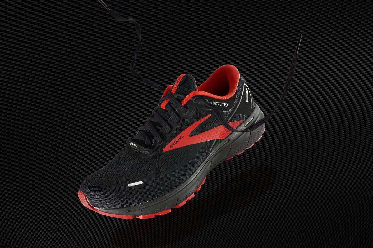 A black and red Brooks Ghost 14 GTX running shoe on a dark background