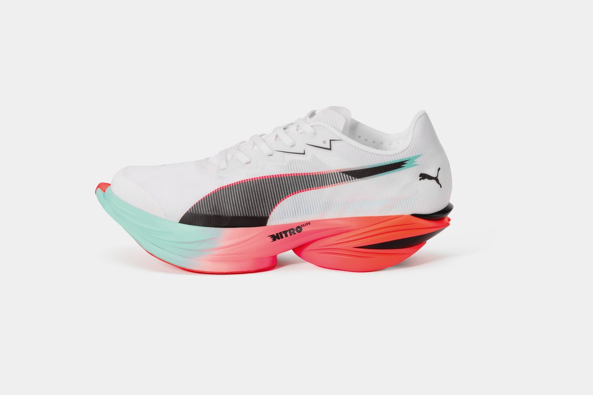 A white Puma Fast-R NITRO Elite 3 racing shoe in profile, with a coral and mint midsole and the carbon plate visible along its side